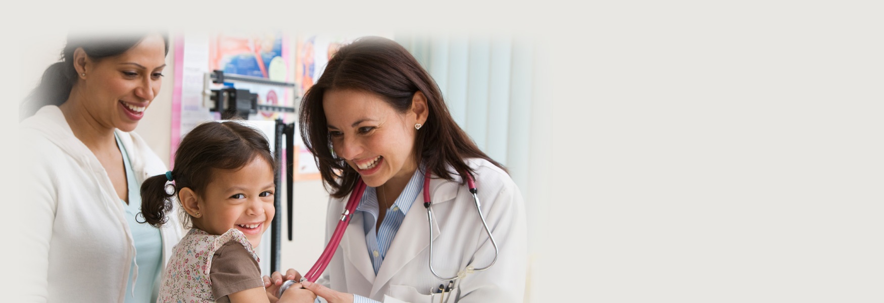 Toddler girl laughing while doctor examines